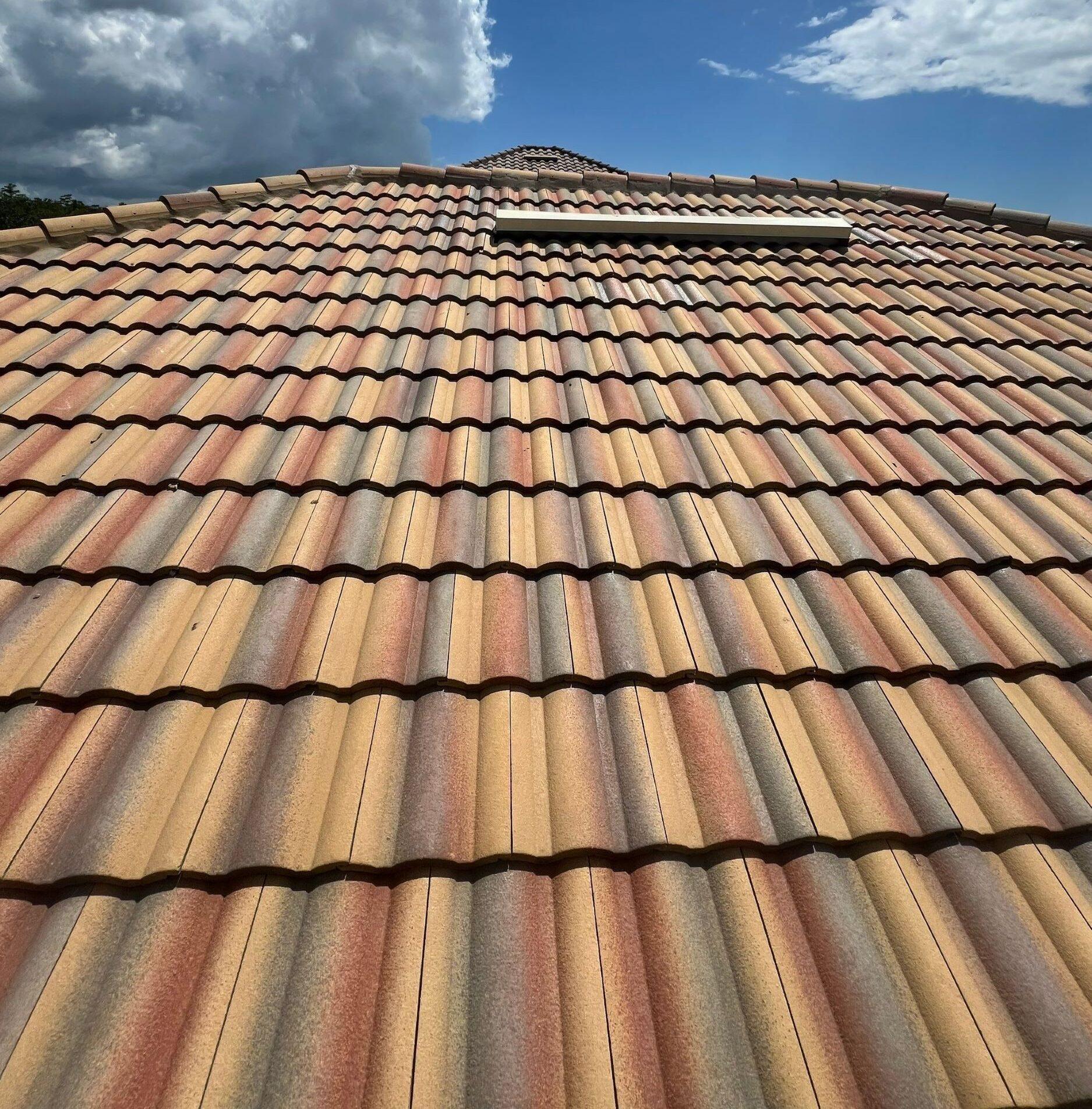 multi-colored tile roof replaced by royalty roofing with blue sky