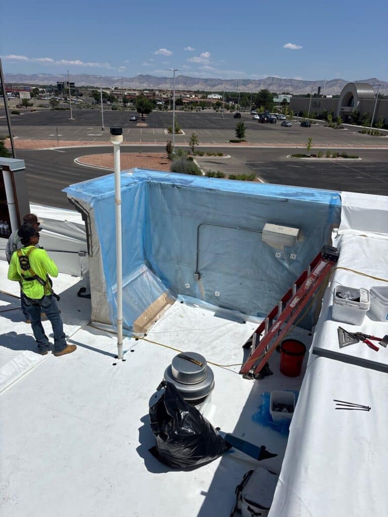 repairing flat roof after storm with blue sheets covering area