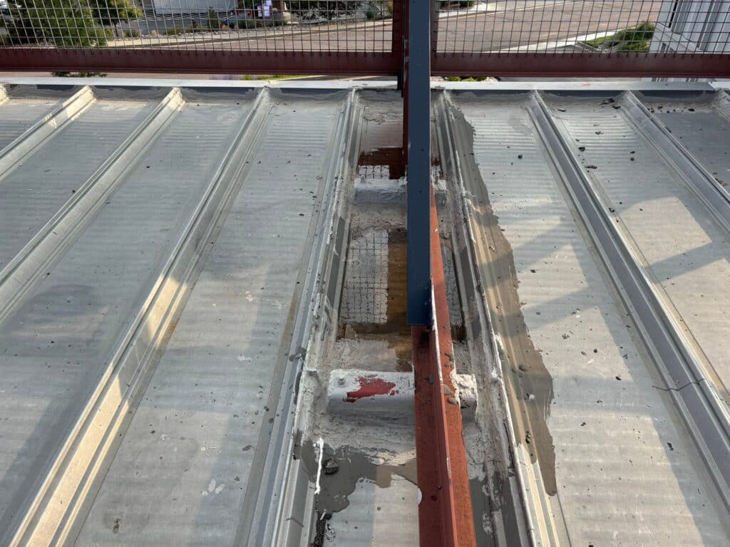 commercial metal roof with water pooling in colorado springs
