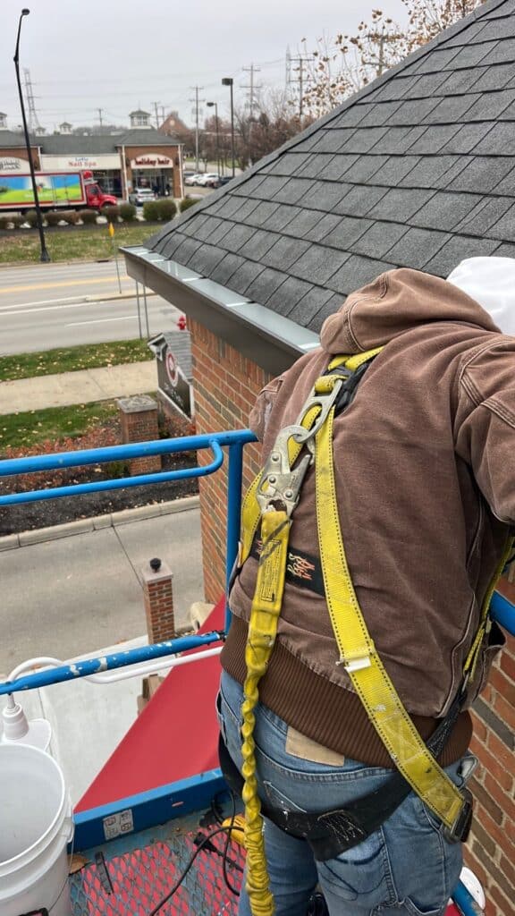 custom box gutters installed on panda express showing man with harness installing brackets