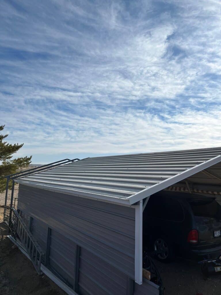 newly installed metal roof on stand alone garage shelter with blue sky in colorado